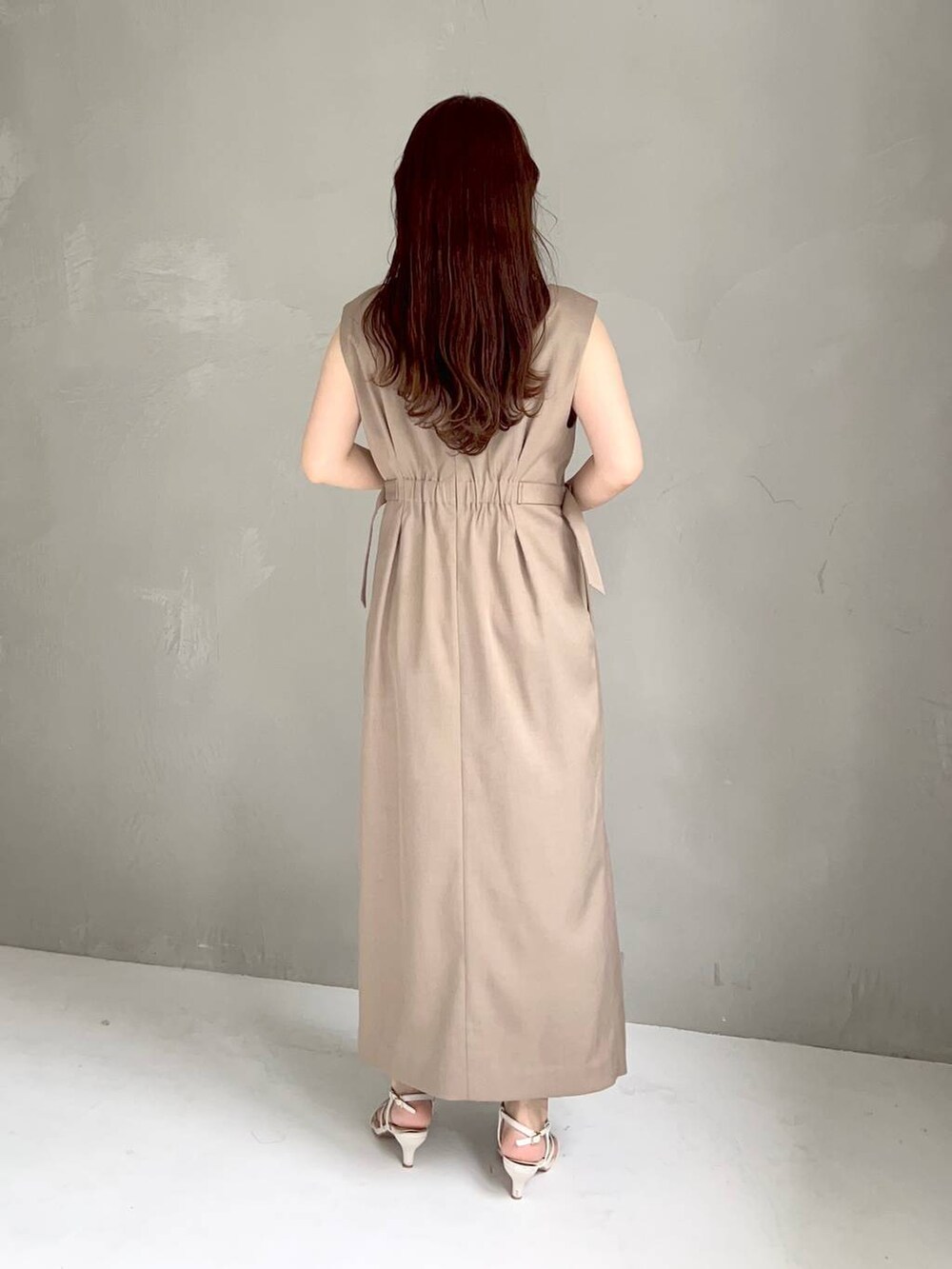 ホワイト系のサンダル、ベージュ系のジャンパースカートを着用したレディースの夏コーディネートの2枚目の写真