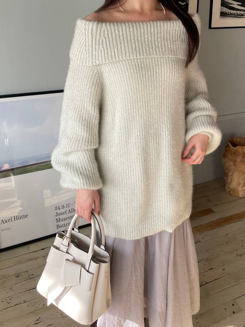 ブラウン系のブーツ、ブルー系のスカート、ホワイト系のショルダーバッグを着用したレディースの冬コーディネートの3枚目の写真