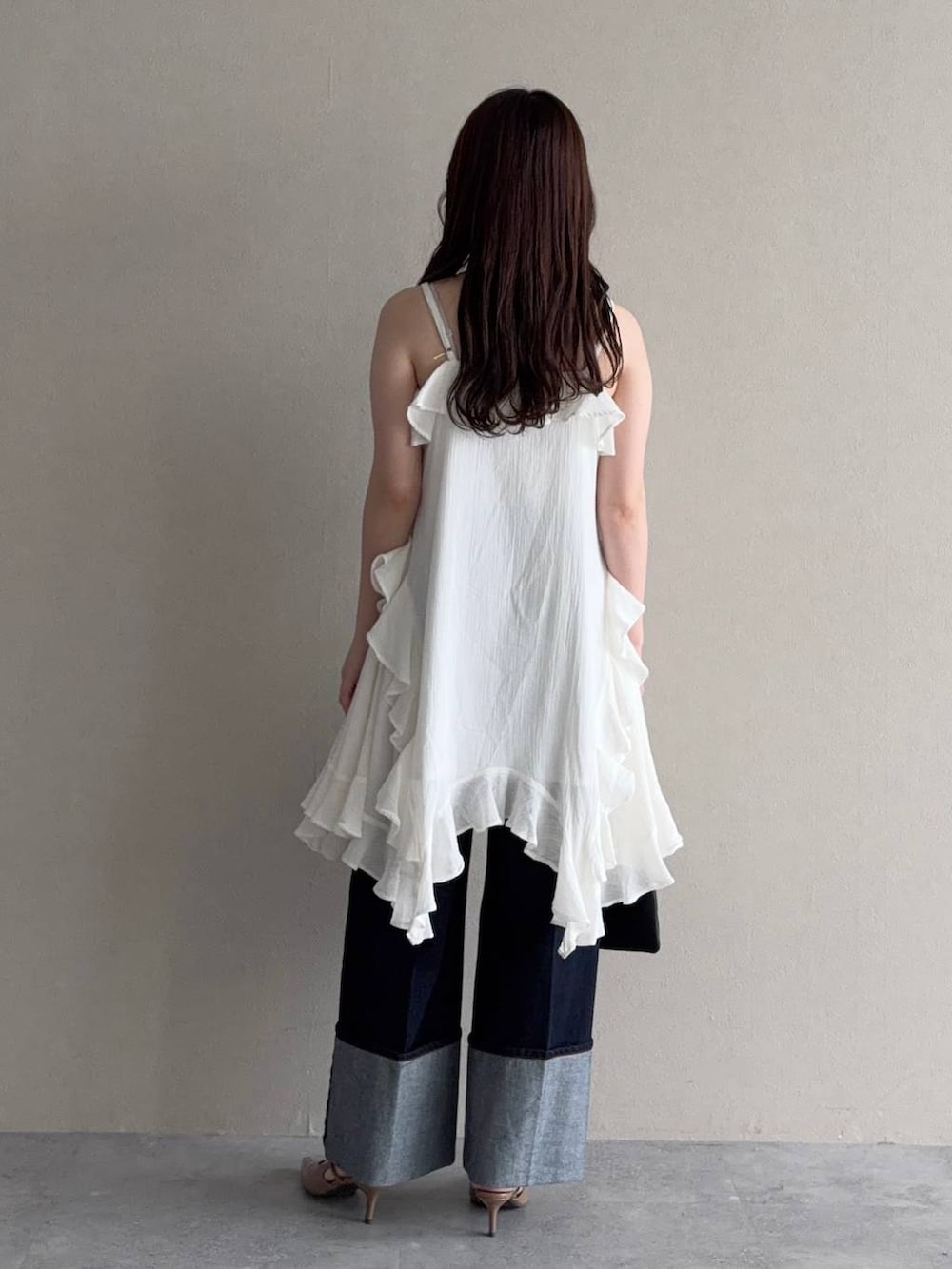 ブラック系のパーカー、ブラウン系のサンダル、ブルー系のデニムパンツを着用したレディースの春コーディネートの4枚目の写真