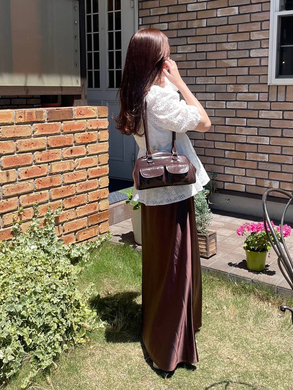 ブラウン系のスカート、ホワイト系のシャツ/ブラウスを着用したレディースの夏コーディネートの4枚目の写真