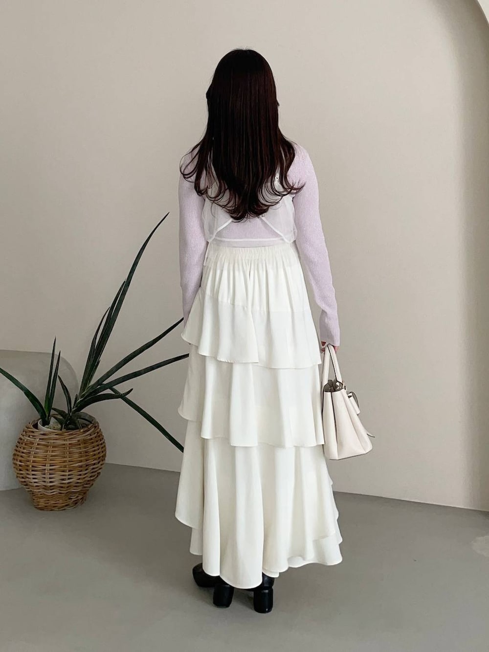 ホワイト系のスカート、ホワイト系のショルダーバッグ、ブラック系のパンプスを着用したレディースの冬コーディネートの4枚目の写真