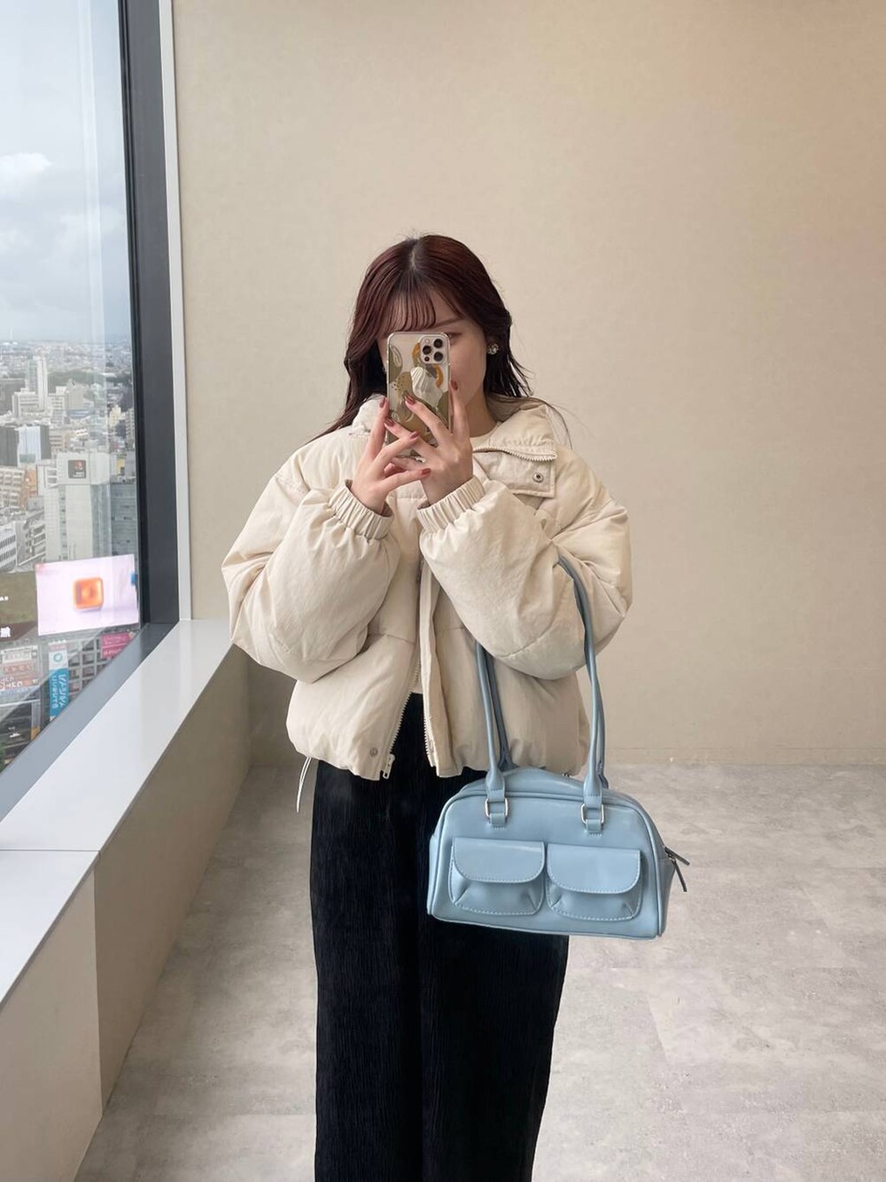 ホワイト系のブルゾン、ホワイト系のブーツ、ブラック系のスカートを着用したレディースの秋コーディネートの6枚目の写真