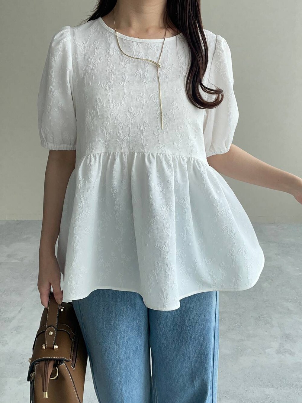 ゴールド系のパンプス、ブラウン系のショルダーバッグ、ホワイト系のシャツ/ブラウスを着用したレディースの夏コーディネートの3枚目の写真