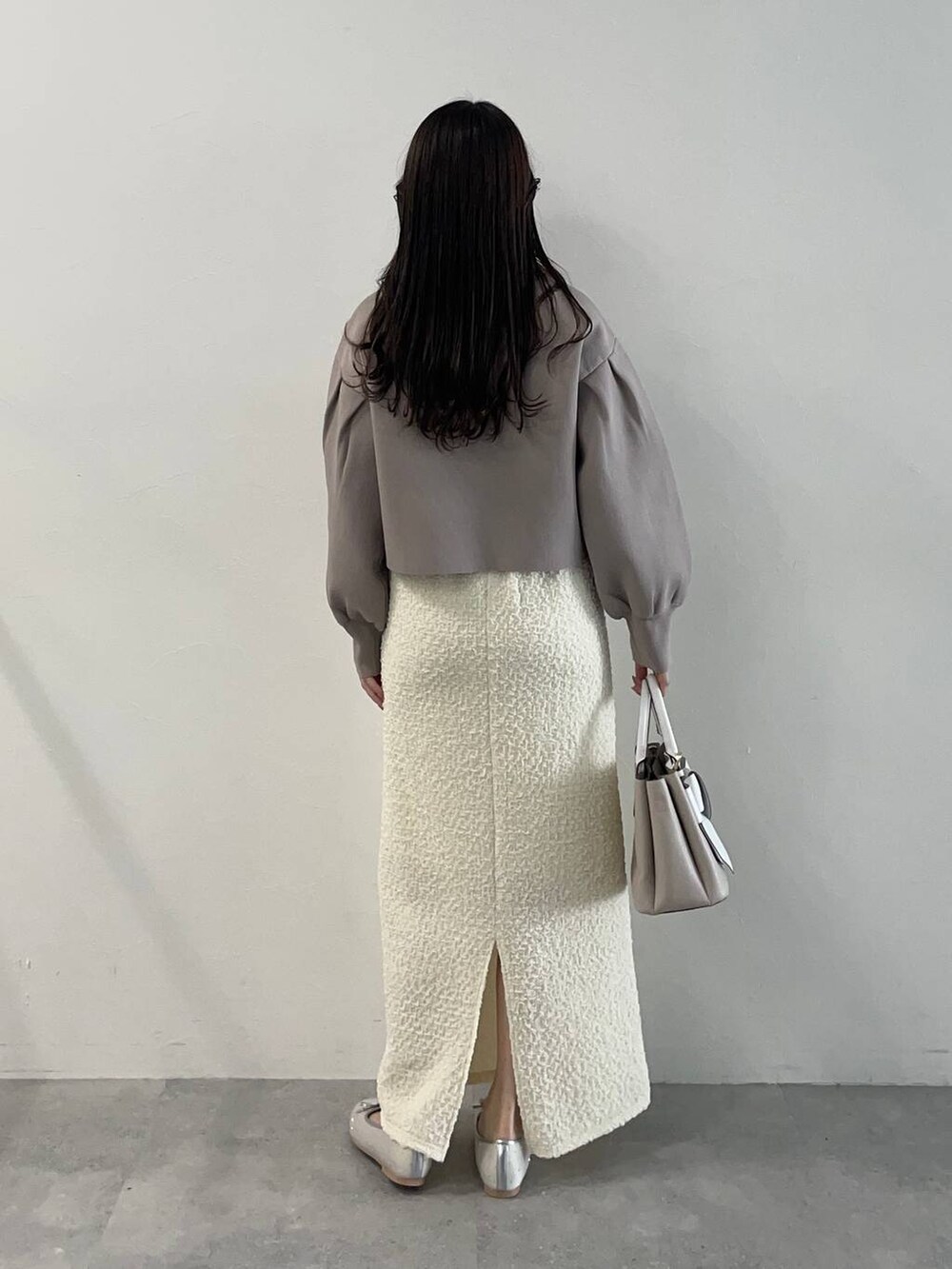 ベージュ系のショルダーバッグ、シルバー系のバレエシューズ、ホワイト系のスカートを着用したレディースの春コーディネートの2枚目の写真