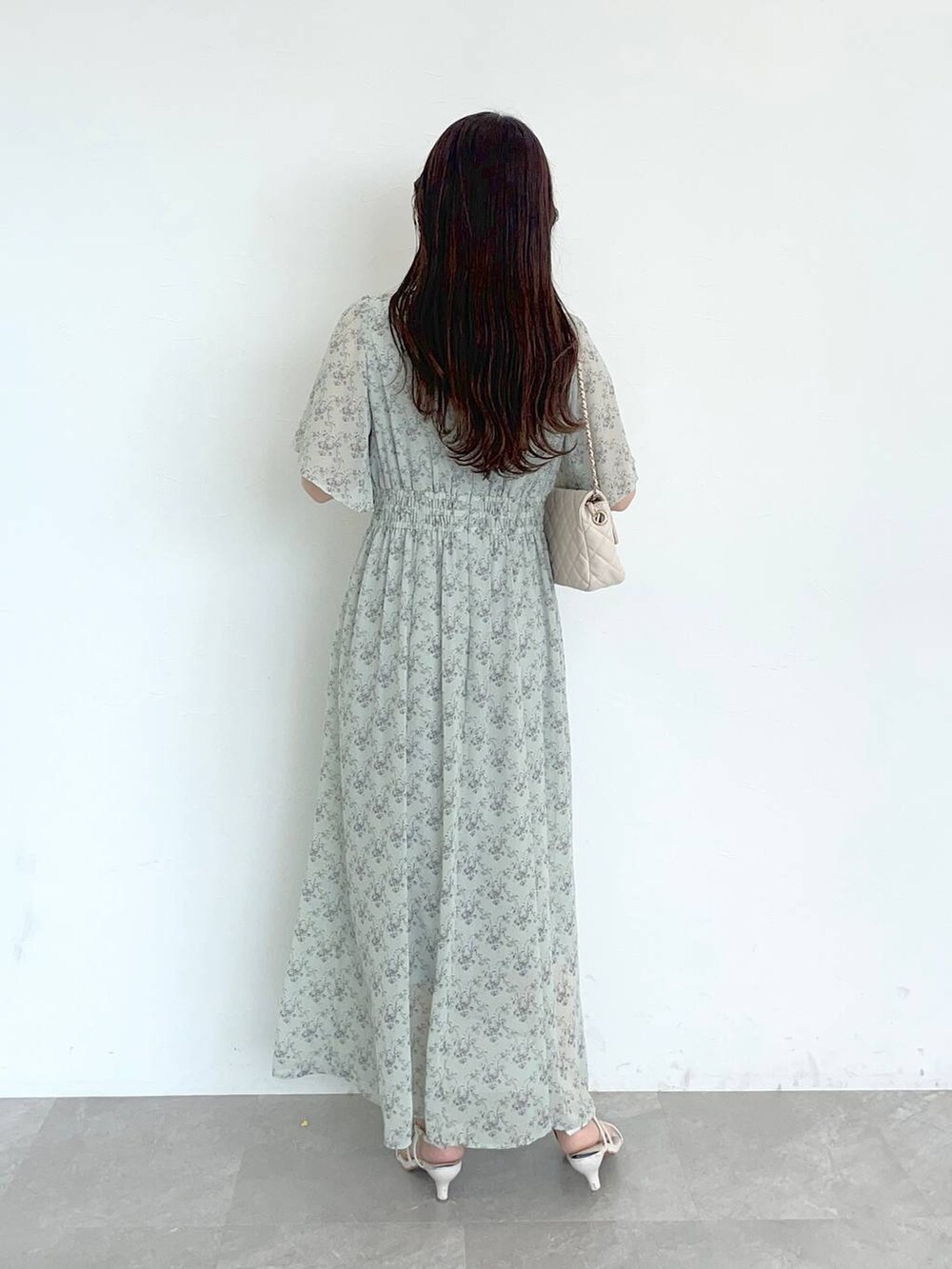 グリーン系のワンピース、ホワイト系のショルダーバッグ、ホワイト系のサンダルを着用したレディースの夏コーディネートの2枚目の写真