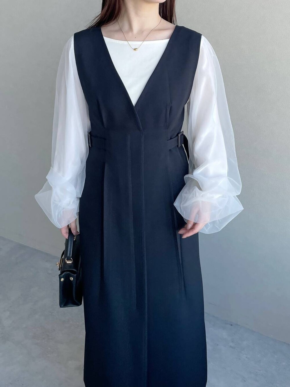 ブルー系のジャンパースカート、ブラック系のバレエシューズ、ホワイト系のTシャツ/カットソーを着用したレディースの冬コーディネートの3枚目の写真