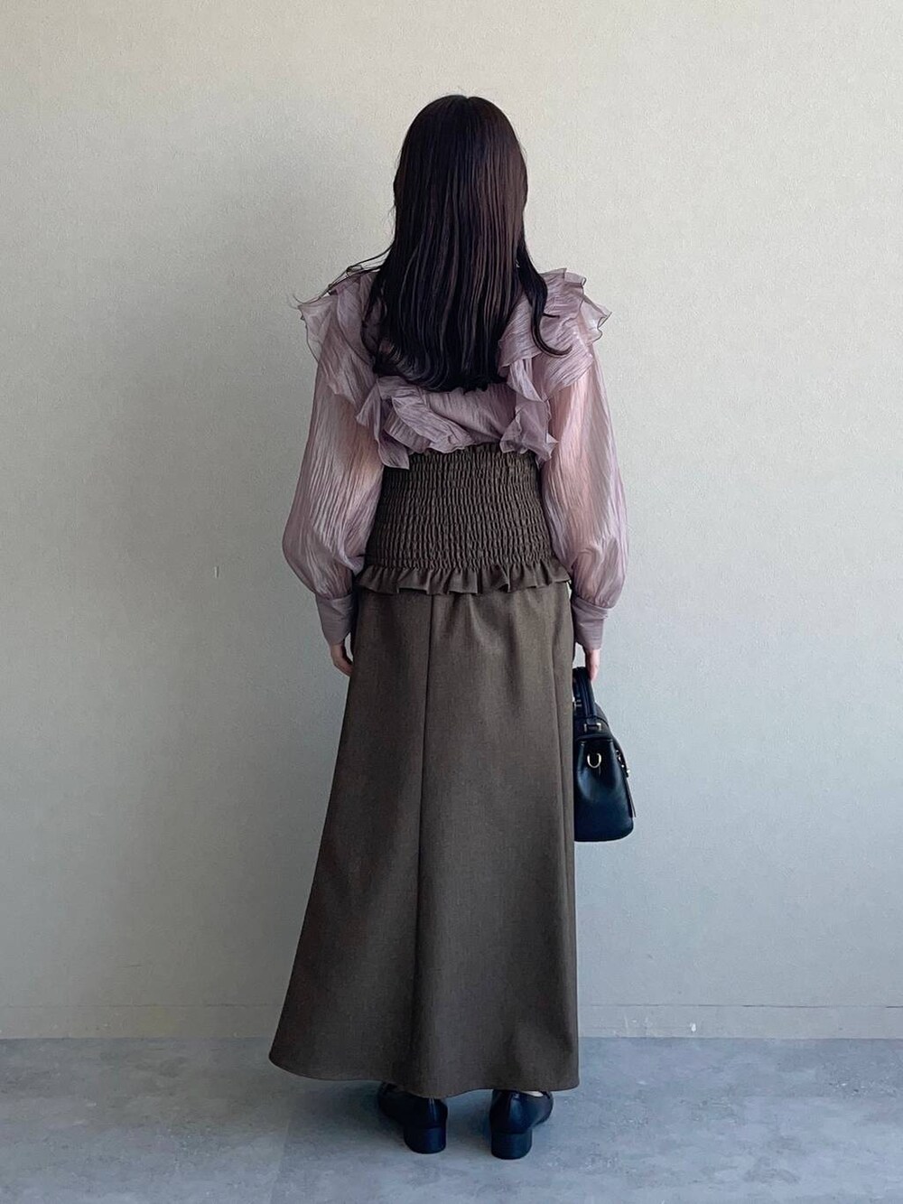 ブラウン系のシャツ/ブラウス、ブラウン系のスカート、ブラック系のローファーを着用したレディースの秋コーディネートの2枚目の写真