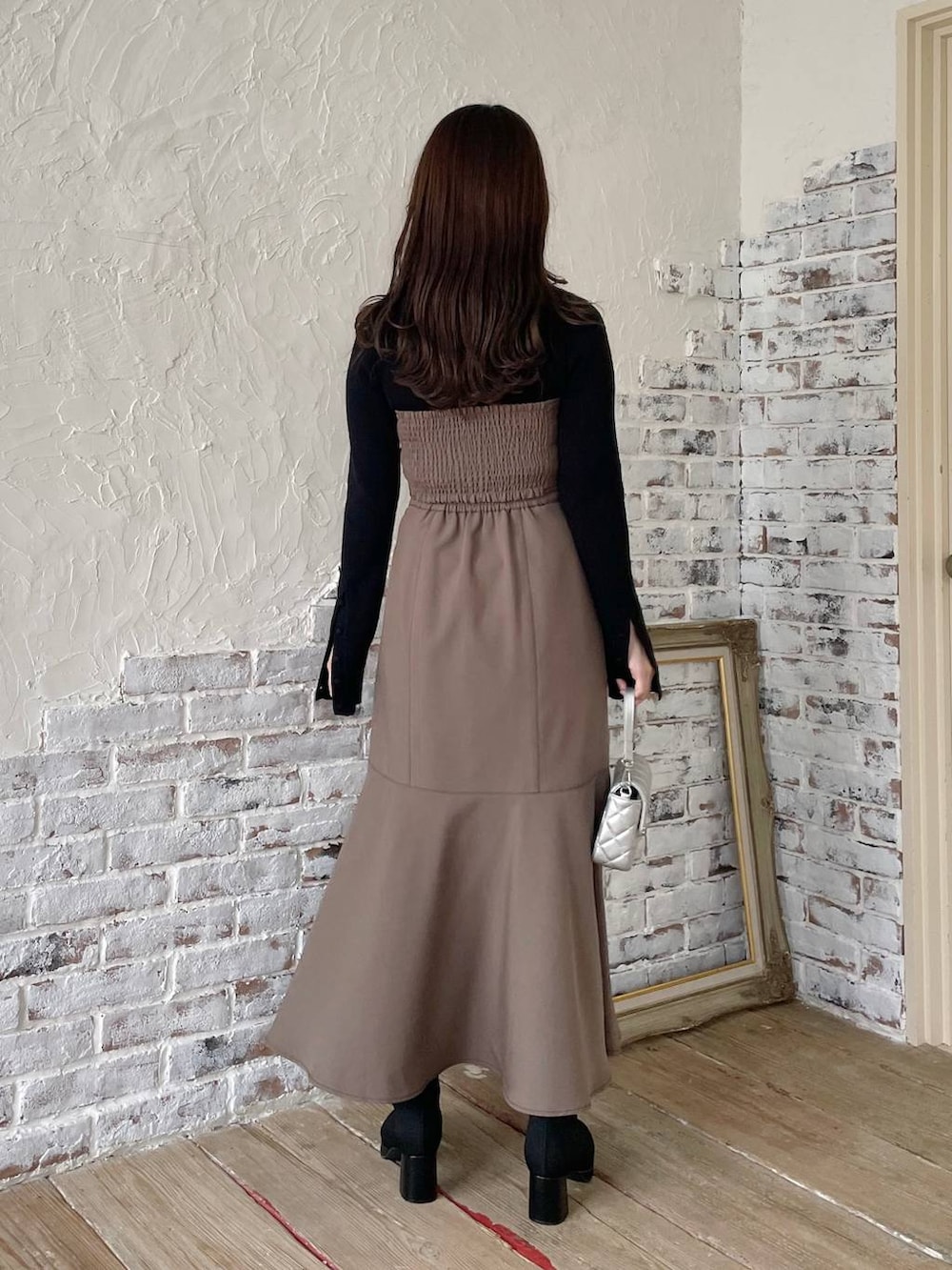 ブラック系のブーツ、ブラウン系のスカート、ブラック系のニット/セーターを着用したレディースの秋コーディネートの3枚目の写真