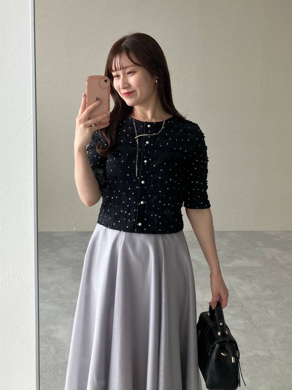 ブラック系のパンプス、ブラック系のショルダーバッグ、ブラック系のカーディガン/ボレロを着用したレディースの夏コーディネートの3枚目の写真