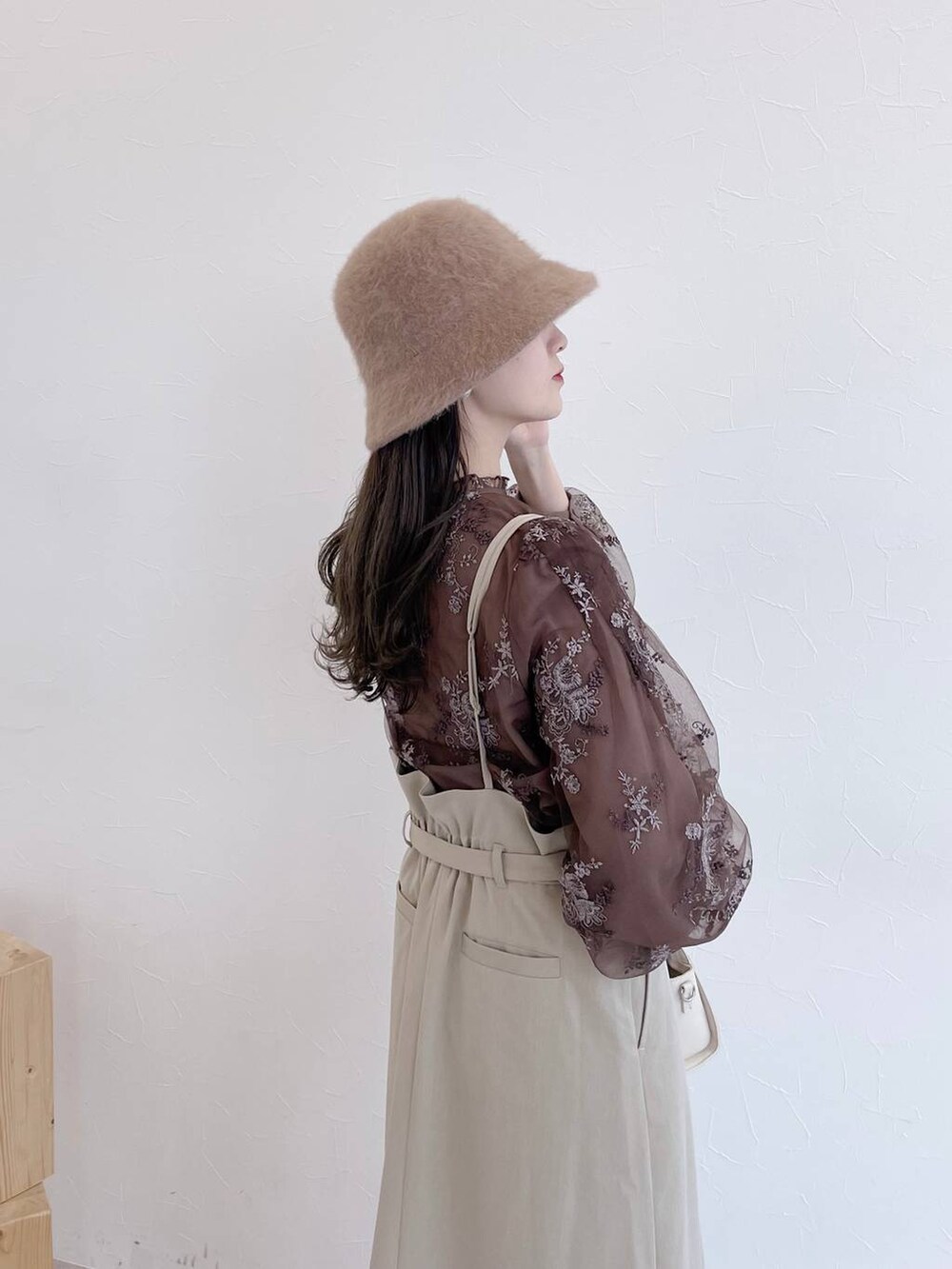 ホワイト系のボストンバッグ、ホワイト系のブーツ、ベージュ系のスカートを着用したレディースの夏コーディネートの5枚目の写真