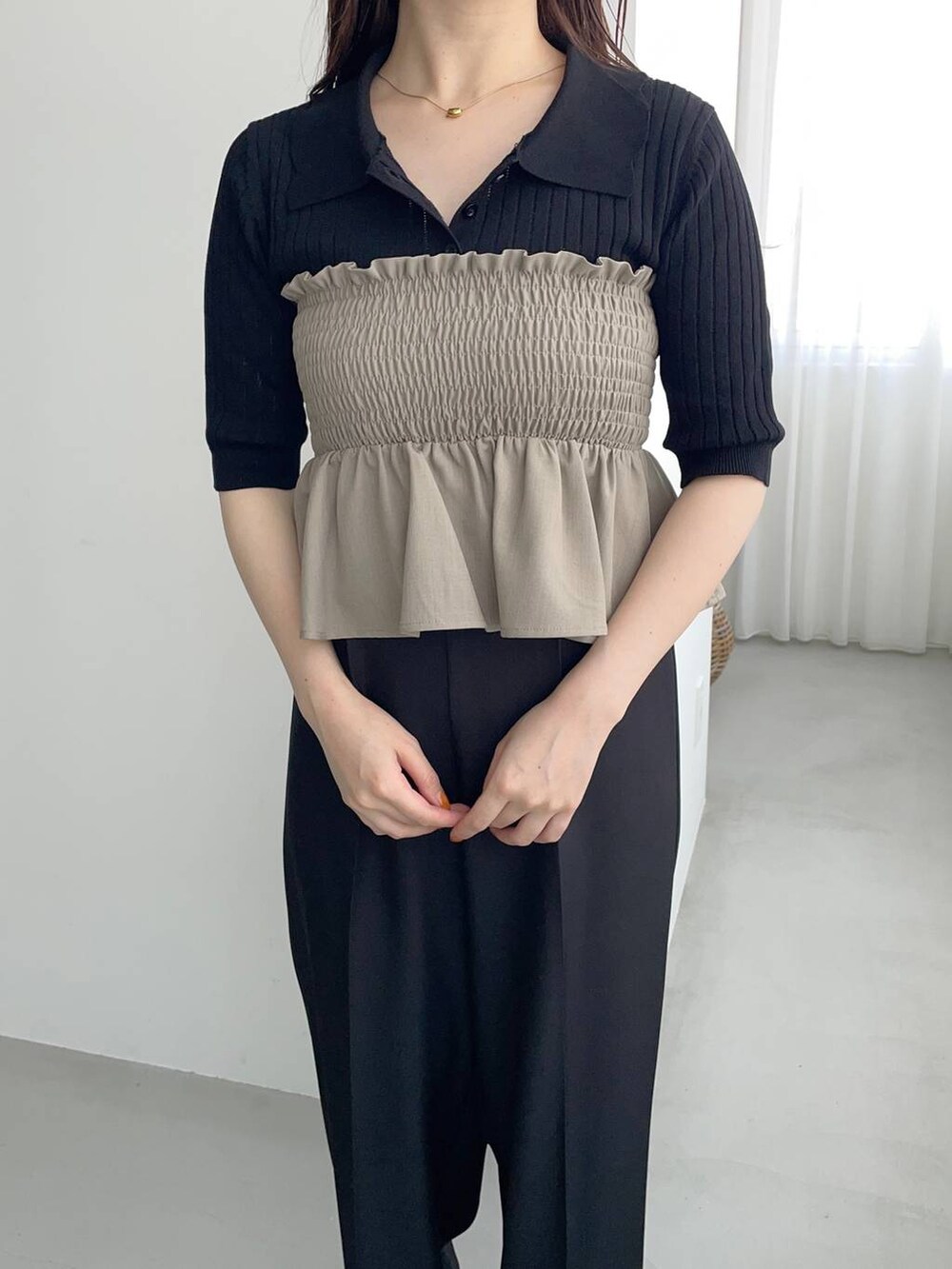 ブラック系のスラックス、ゴールド系のパンプス、グリーン系のスカートを着用したレディースの夏コーディネートの4枚目の写真