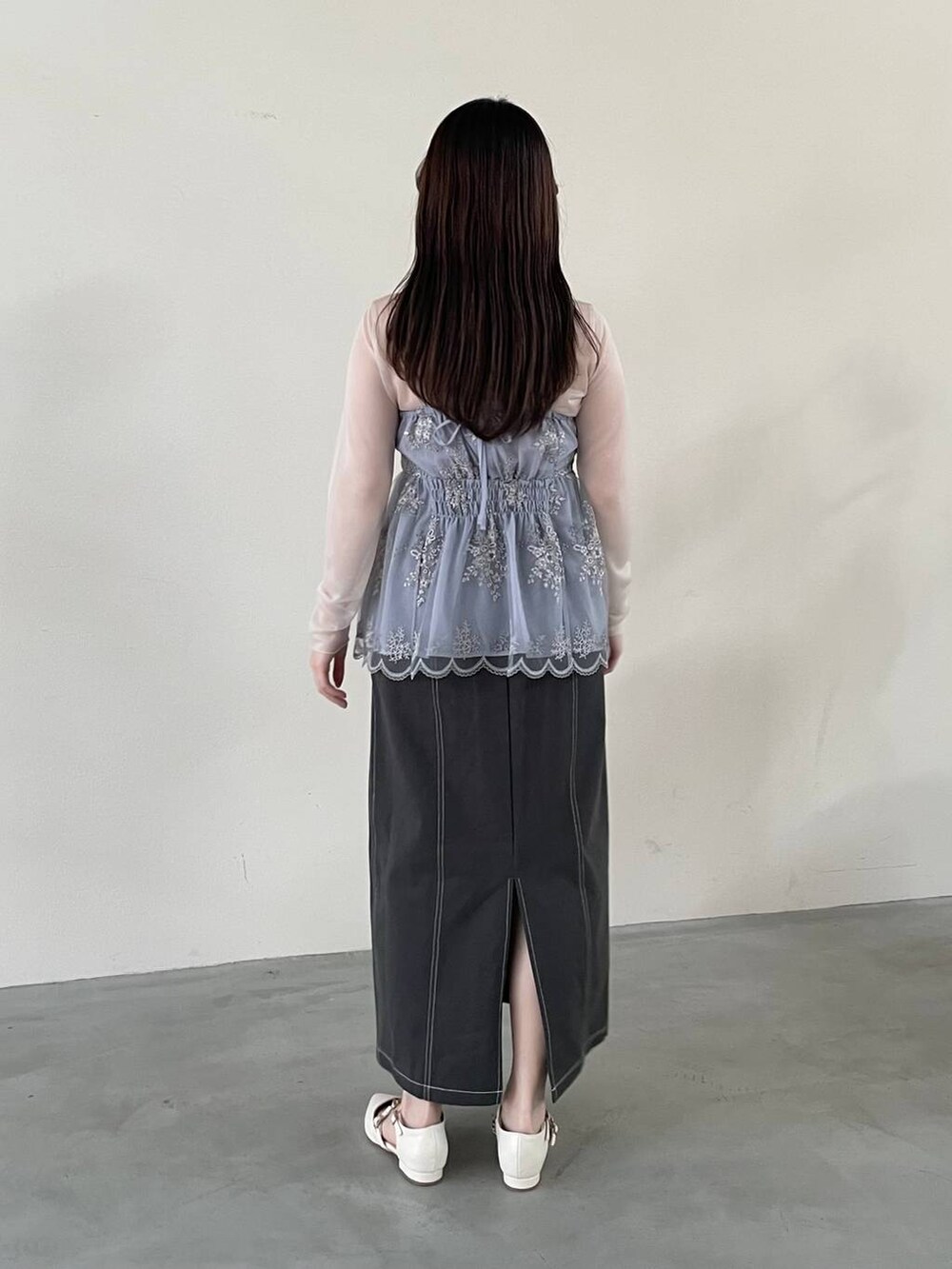 グレー系のスカート、ブルー系のその他トップス、ホワイト系のパンプスを着用したレディースの春コーディネートの2枚目の写真