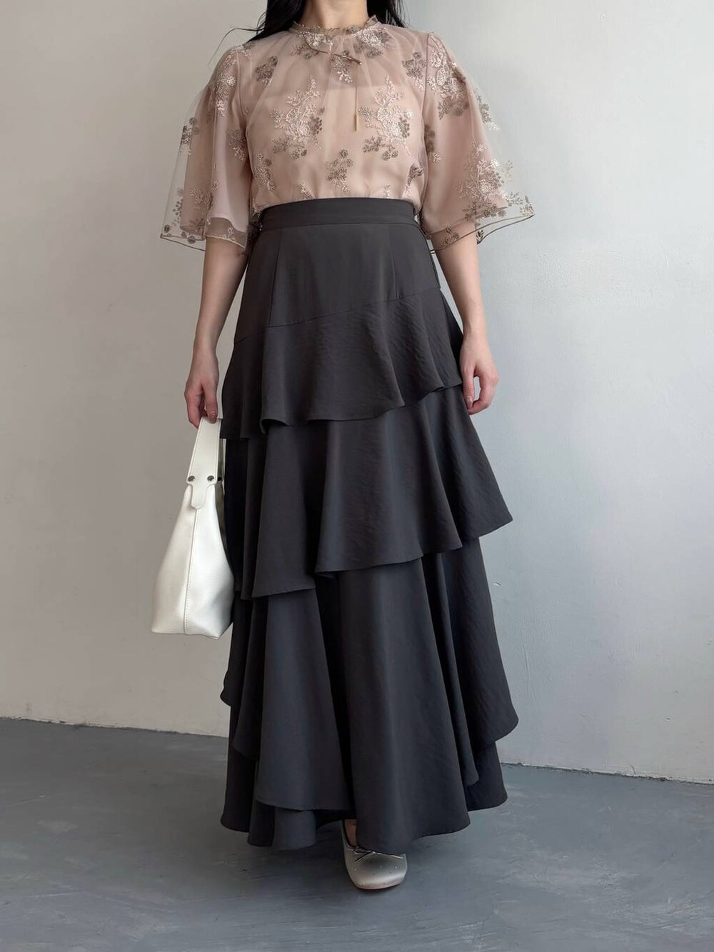 グレー系のスカート、シルバー系のバレエシューズ、ピンク系のシャツ/ブラウスを着用したレディースの春コーディネートの4枚目の写真