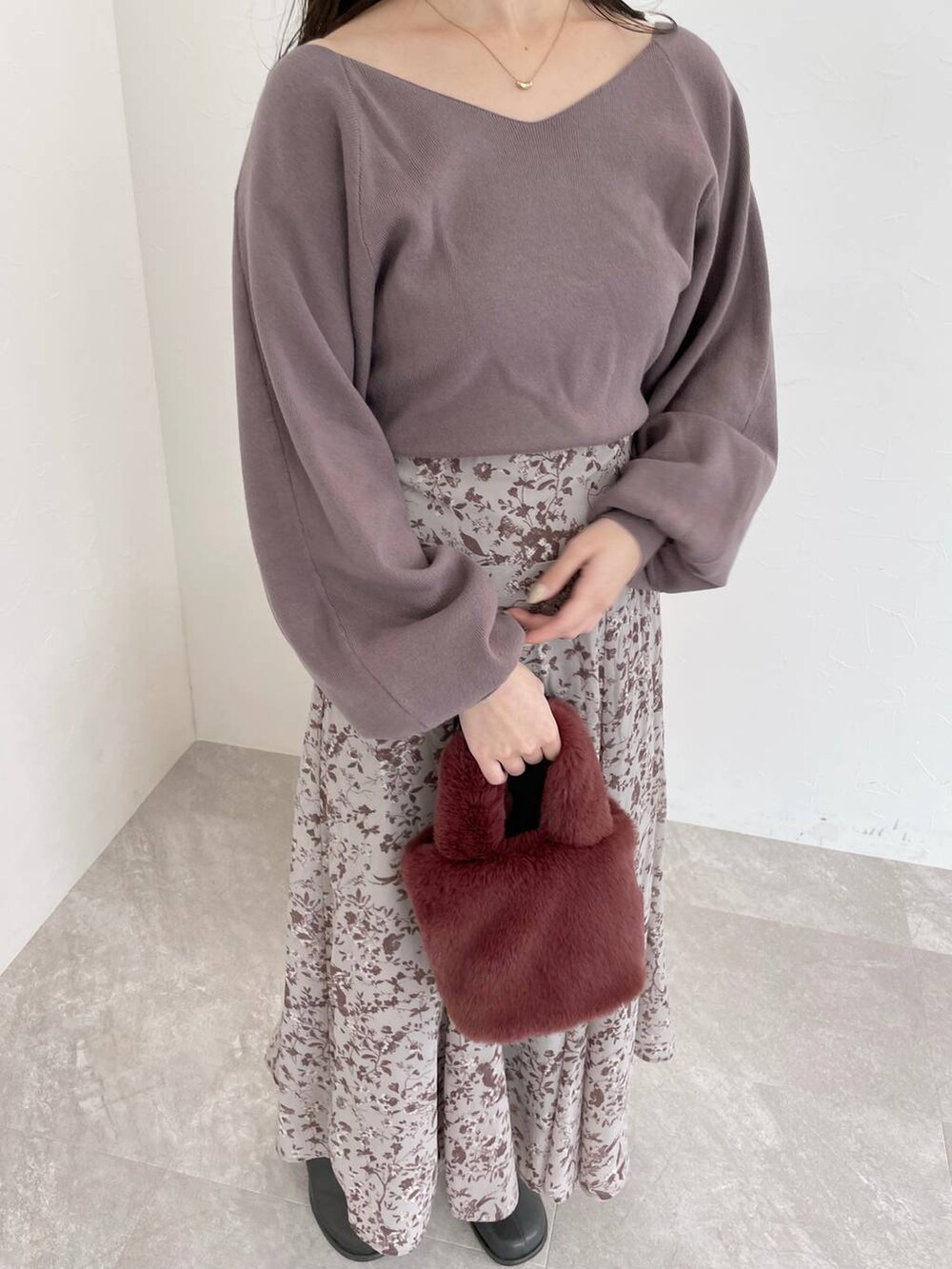 ブラック系のチェスターコート、グレー系のブーツ、ピンク系のハンドバッグを着用したレディースの秋コーディネートの6枚目の写真