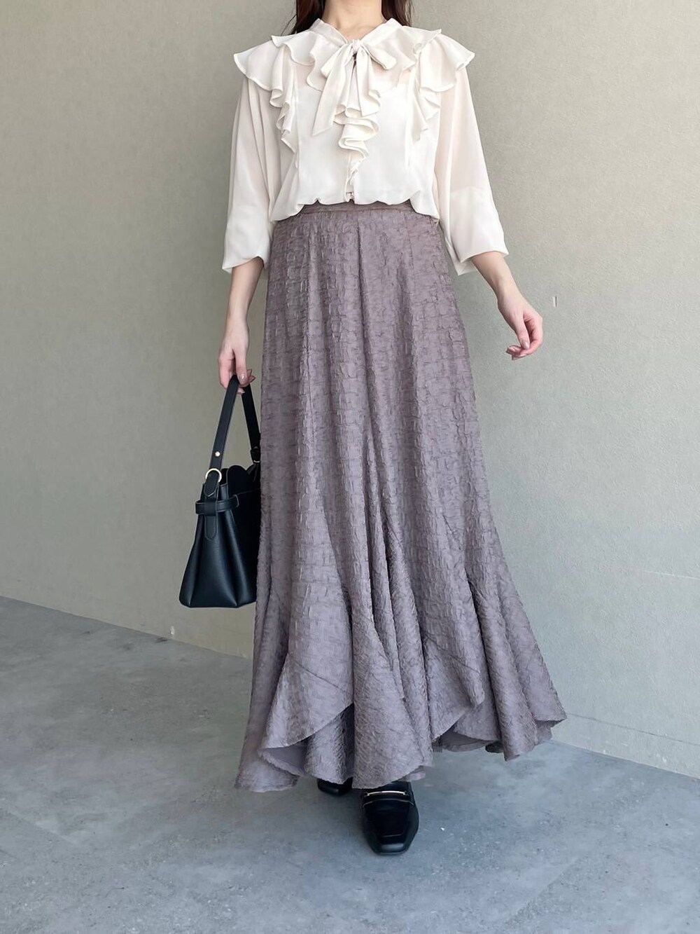 ブラック系のショルダーバッグ、ブラウン系のスカート、ホワイト系のシャツ/ブラウスを着用したレディースの冬コーディネートの4枚目の写真