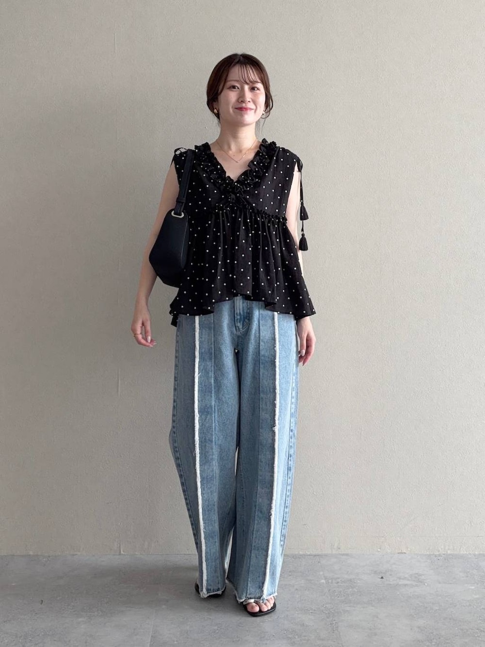 ブラック系のシャツ/ブラウス、ブラック系のサンダル、ブルー系のデニムパンツを着用したレディースの夏コーディネートの2枚目の写真