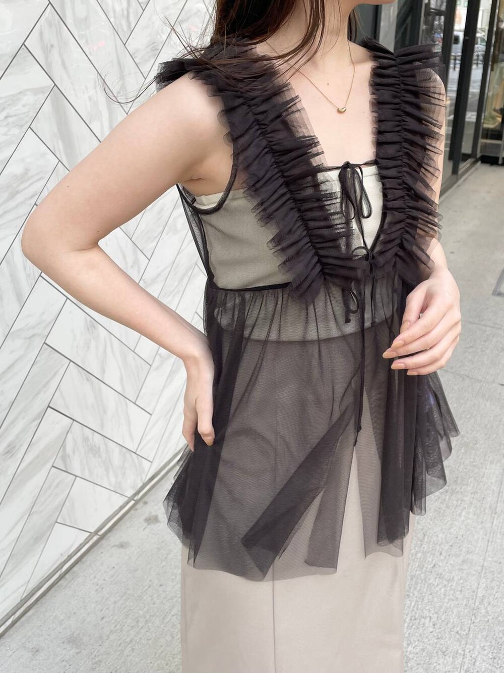 ホワイト系のキャミソール、ベージュ系のサンダル、ブラウン系のショルダーバッグを着用したレディースの夏コーディネートの4枚目の写真