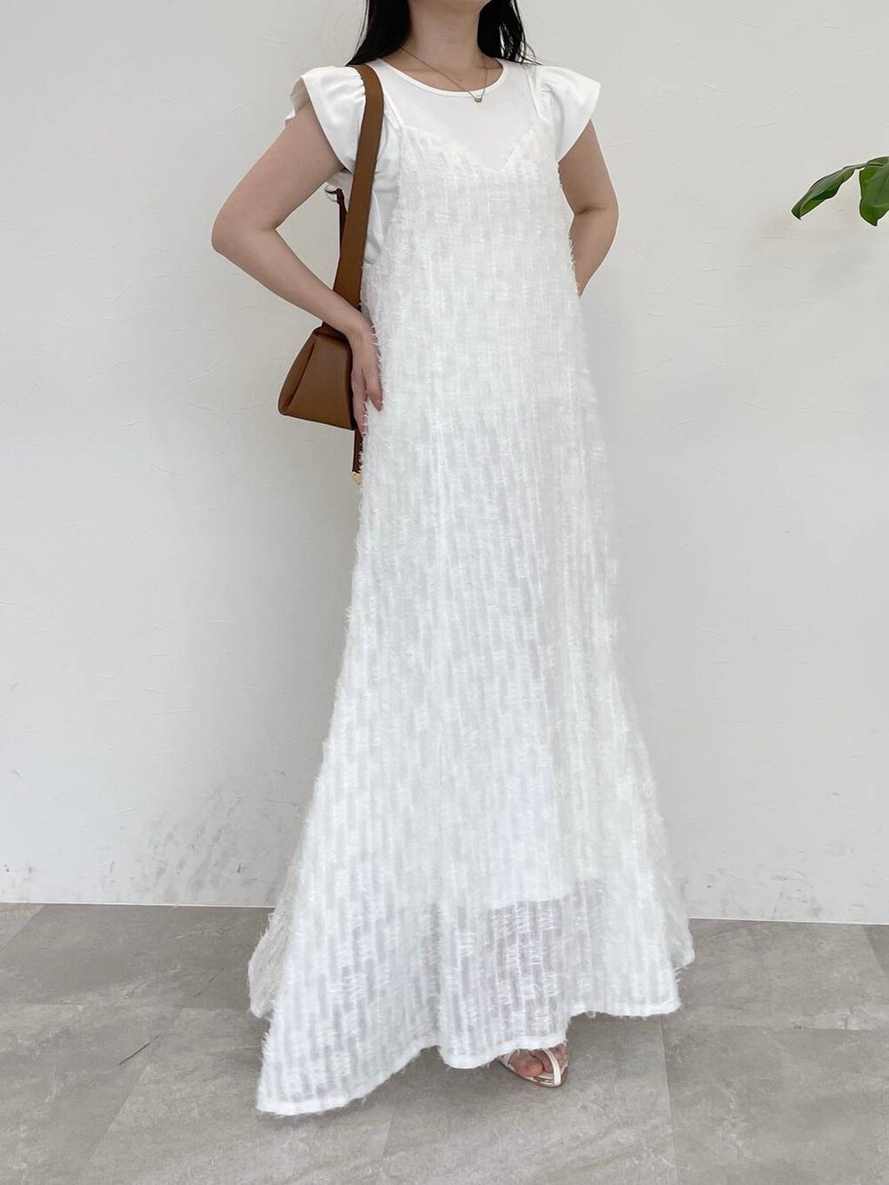 ホワイト系のワンピース、ホワイト系のTシャツ/カットソー、ブラウン系のショルダーバッグを着用したレディースの春コーディネートの4枚目の写真