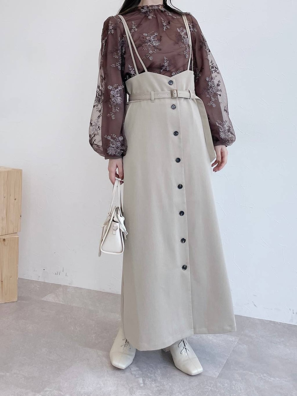 ホワイト系のボストンバッグ、ホワイト系のブーツ、ベージュ系のスカートを着用したレディースの夏コーディネートの6枚目の写真