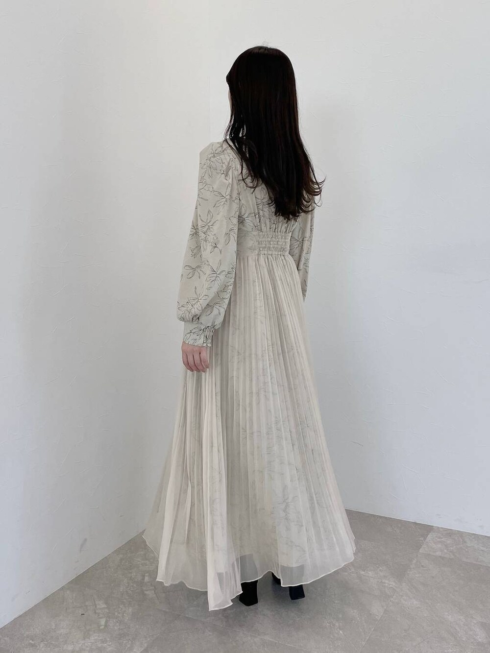 ベージュ系のワンピース、ブラック系のハンドバッグ、ブラック系のブーツを着用したレディースの冬コーディネートの5枚目の写真