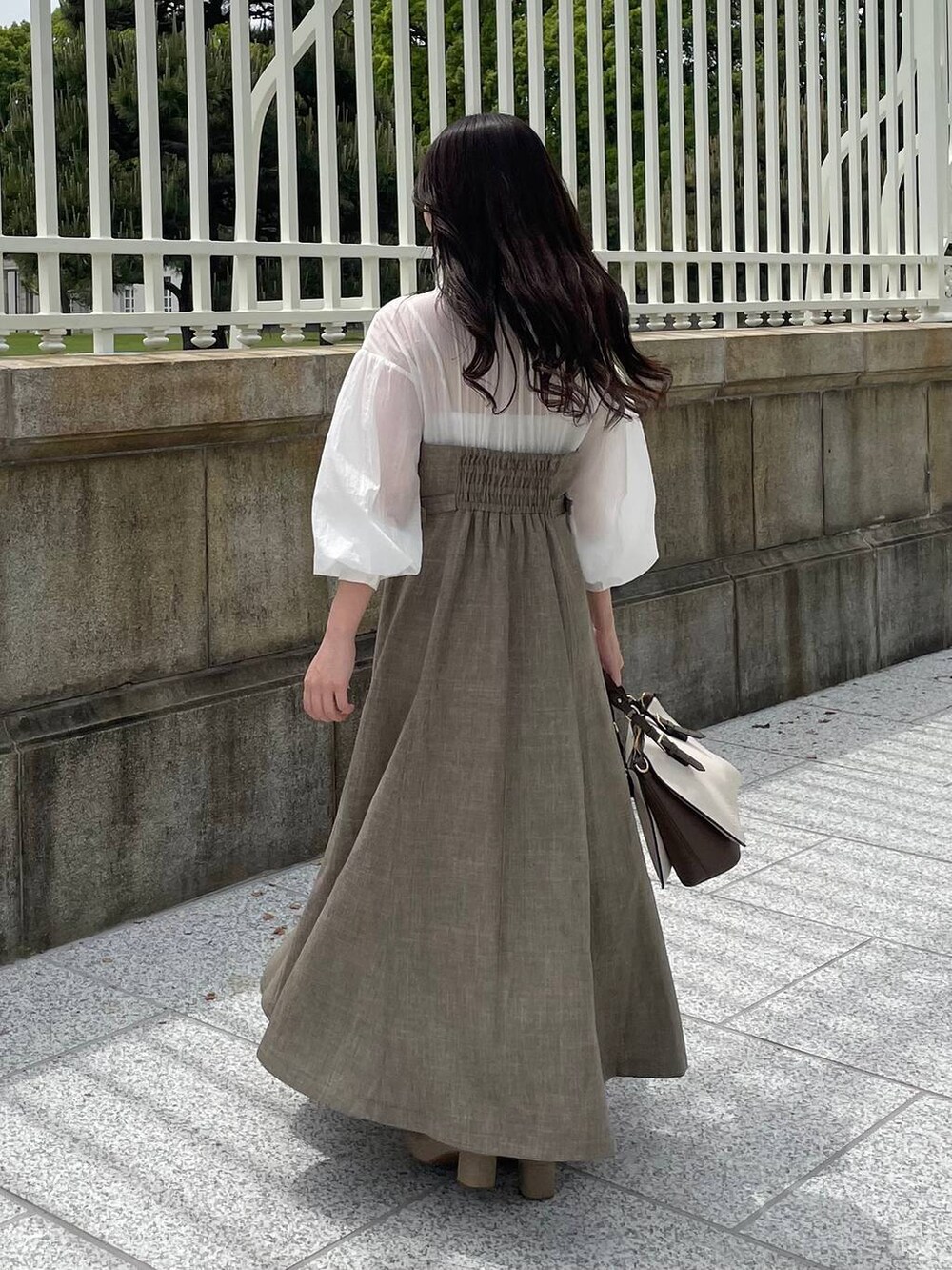 ベージュ系のワンピース、ホワイト系のトートバッグを着用したレディースの春コーディネートの3枚目の写真