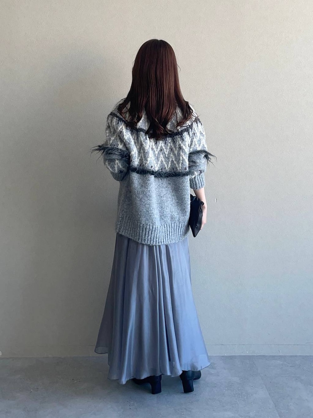 ブラック系のハンドバッグ、グレー系のスカートを着用したレディースの冬コーディネートの2枚目の写真