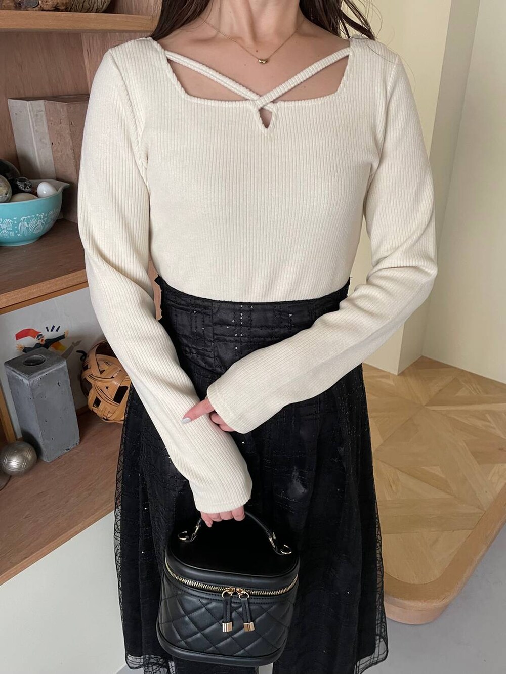 ホワイト系のブーツ、ブラック系のショルダーバッグ、ブラック系のスカートを着用したレディースの冬コーディネートの3枚目の写真