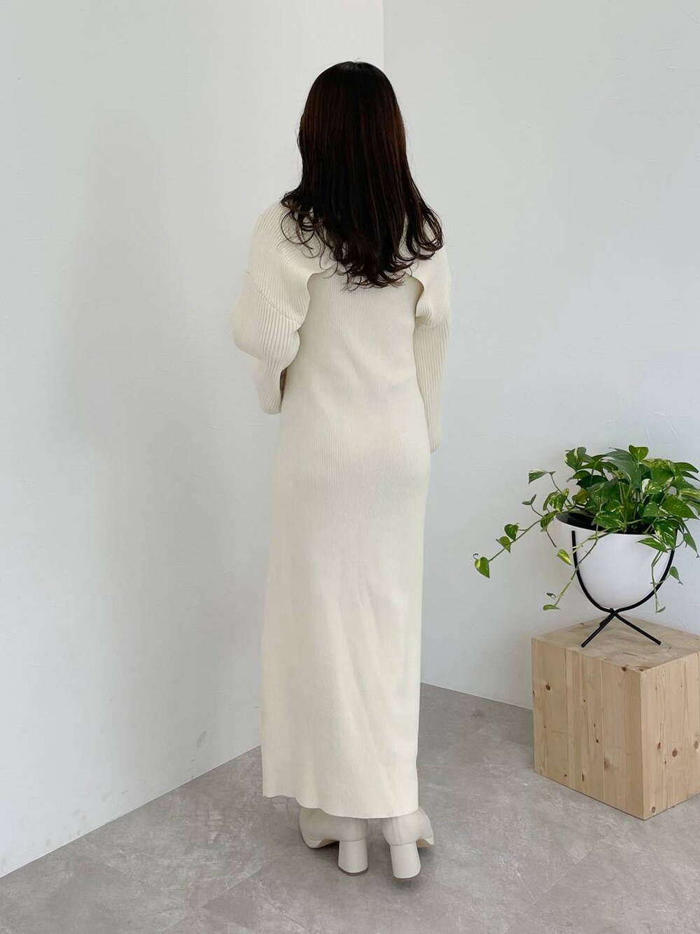 ホワイト系のブーツ、ホワイト系のハンドバッグ、ブラウン系のチェスターコートを着用したレディースの秋コーディネートの6枚目の写真