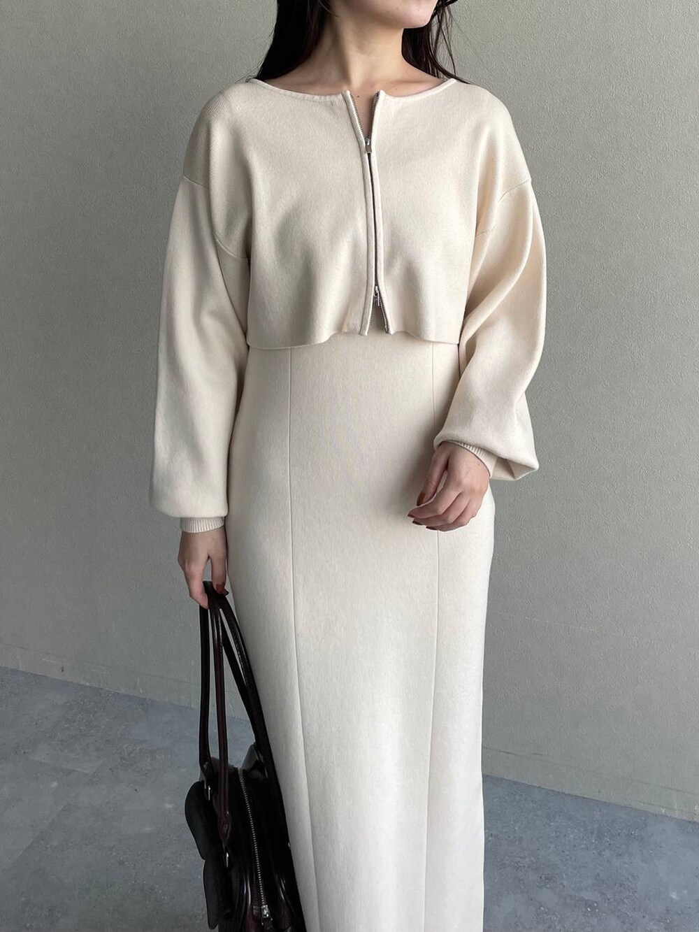 ブルー系のチェスターコート、ブラウン系のブーツ、ホワイト系のワンピースを着用したレディースの冬コーディネートの5枚目の写真