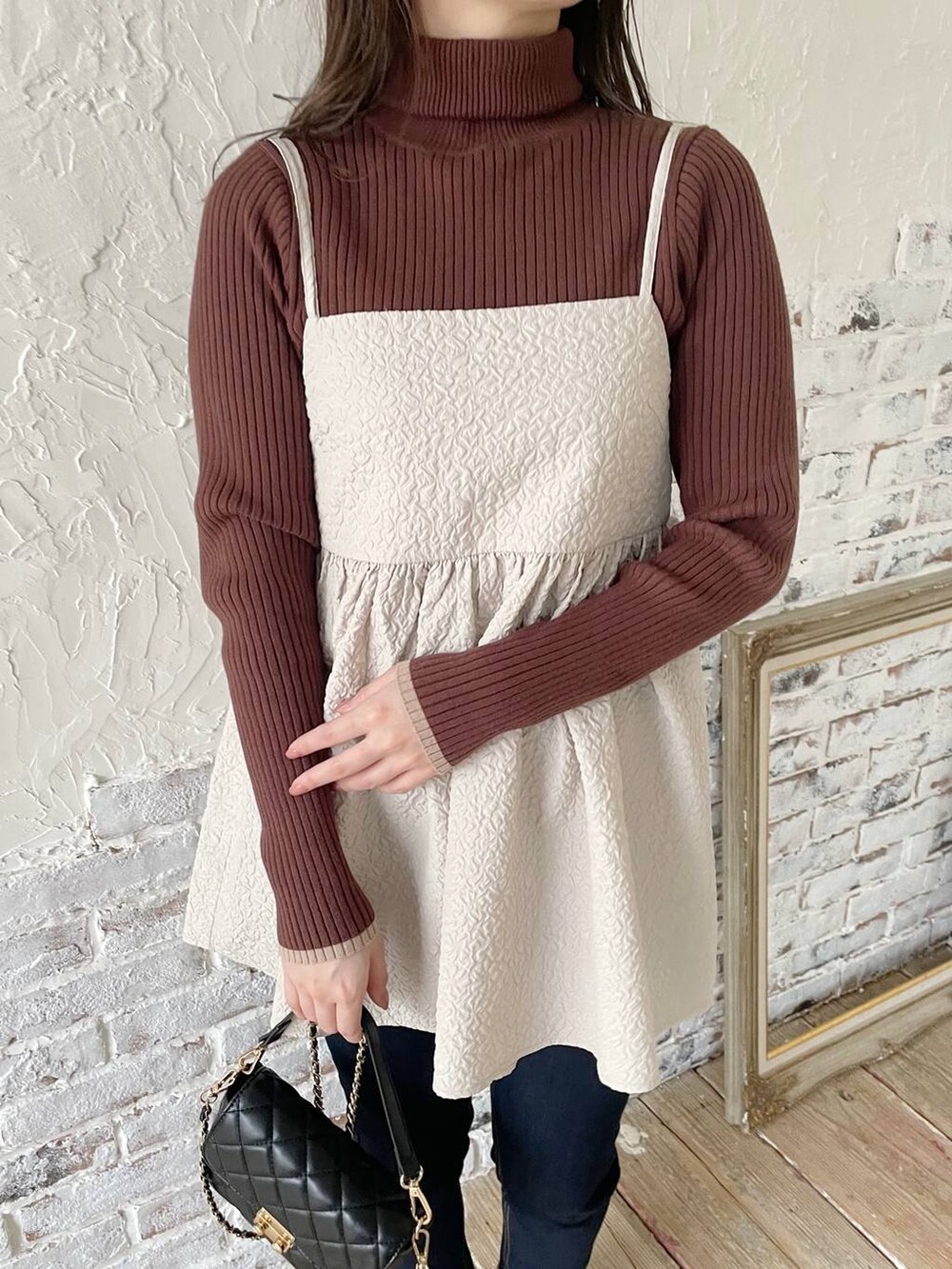 ブルー系のデニムパンツ、ベージュ系のキャミソール、ブラウン系のニット/セーターを着用したレディースの冬コーディネートの3枚目の写真