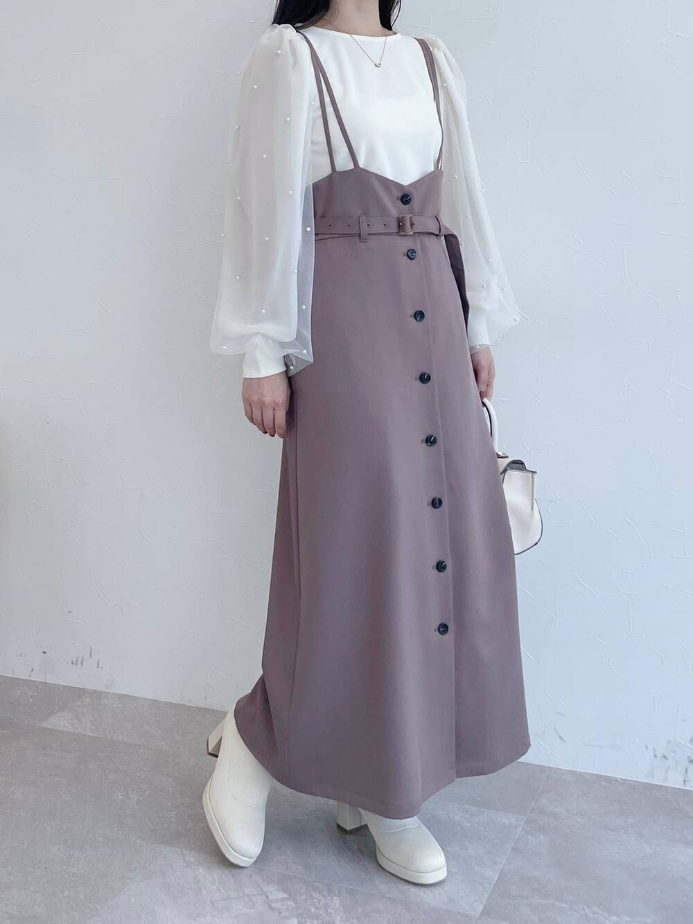 ブラウン系のチェスターコート、ホワイト系のハンドバッグ、ホワイト系のブーツを着用したレディースの夏コーディネートの8枚目の写真