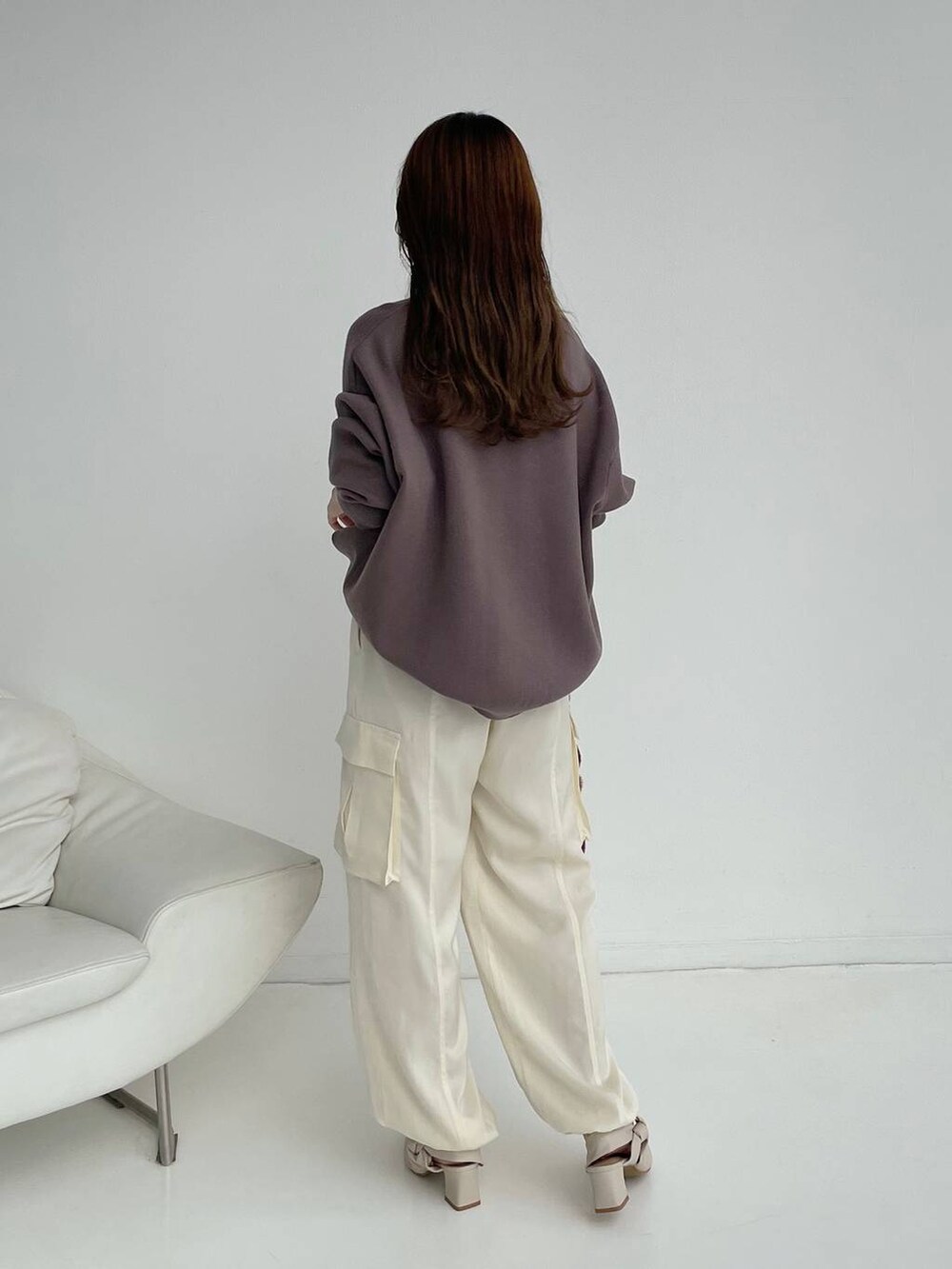 ホワイト系のパンプス、ピンク系のハンドバッグ、ブラウン系のニット/セーターを着用したレディースの秋コーディネートの2枚目の写真