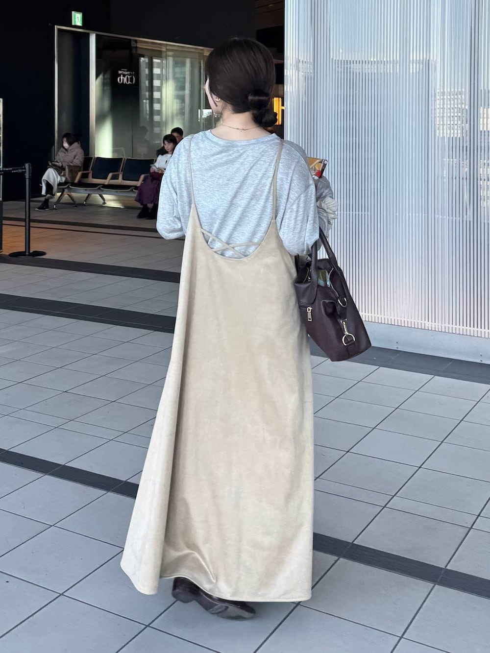 グレー系のTシャツ/カットソー、ブラウン系のボストンバッグ、ベージュ系のワンピースを着用したレディースの冬コーディネートの2枚目の写真