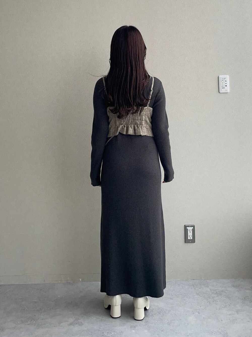 ブラック系のチェスターコート、ホワイト系のブーツ、グレー系のワンピースを着用したレディースの秋コーディネートの4枚目の写真