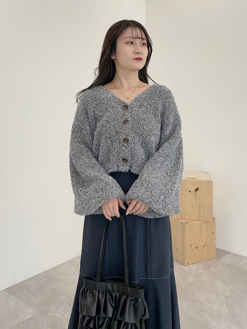 ブラック系のブーツ、グレー系のスカート、ブラック系のトートバッグを着用したレディースの秋コーディネートの3枚目の写真