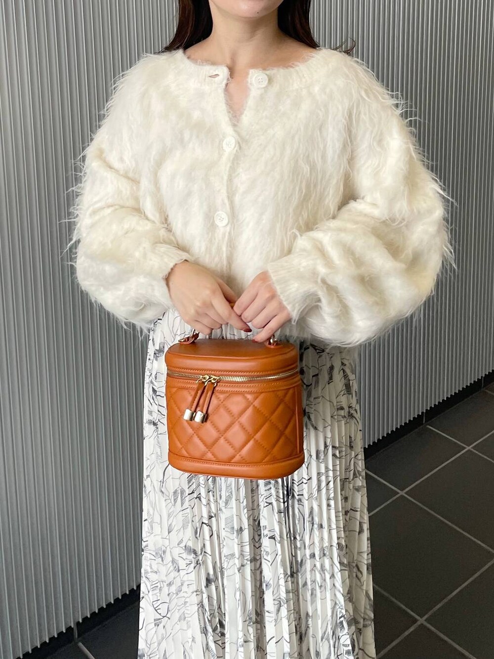 ホワイト系のカーディガン/ボレロ、ホワイト系のブーツ、オレンジ系のショルダーバッグを着用したレディースの秋コーディネートの4枚目の写真