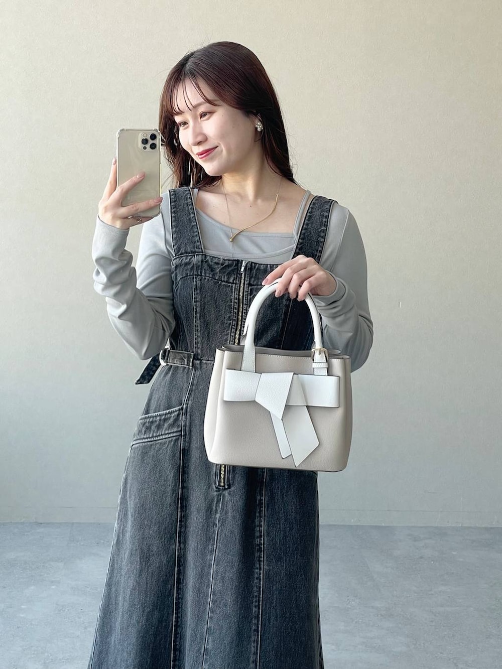 ブラック系のジャンパースカート、ベージュ系のショルダーバッグ、シルバー系のバレエシューズを着用したレディースの冬コーディネートの5枚目の写真