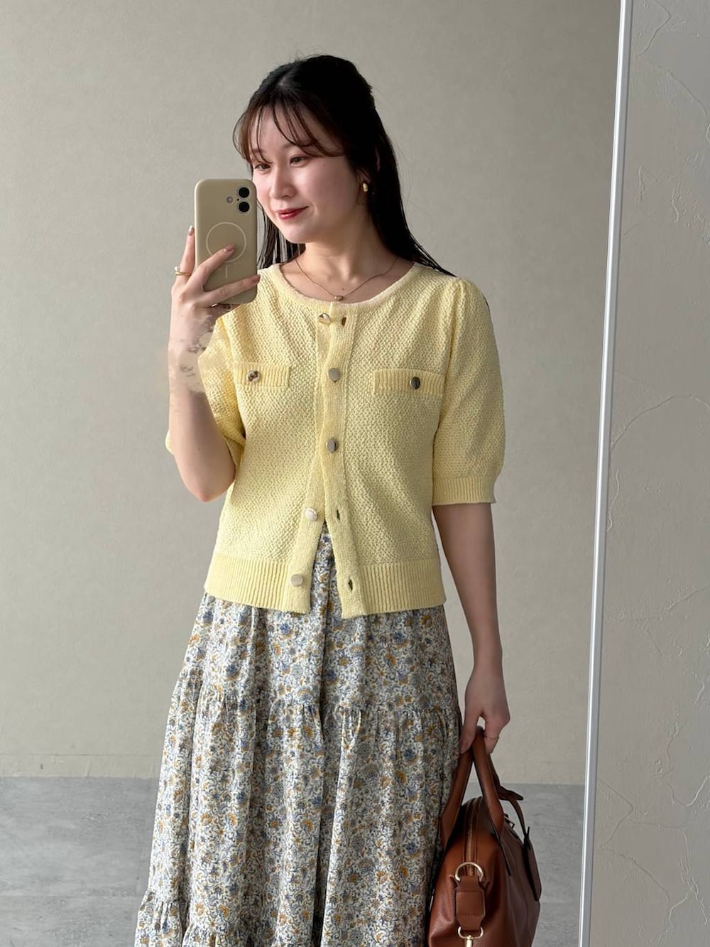 ブラウン系のボストンバッグ、イエロー系のカーディガン/ボレロ、ブラウン系のサンダルを着用したレディースの春コーディネートの3枚目の写真