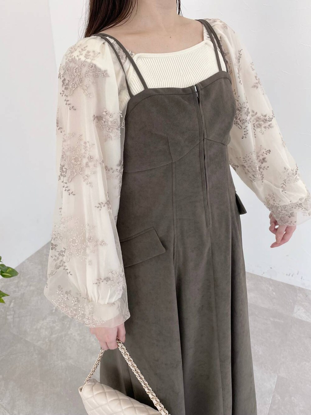 グレー系のワンピース、ホワイト系のショルダーバッグ、ホワイト系のニット/セーターを着用したレディースの冬コーディネートの4枚目の写真