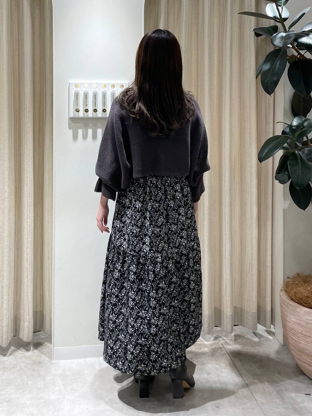 グレー系のブーツ、ブラック系のワンピースを着用したレディースの冬コーディネートの2枚目の写真