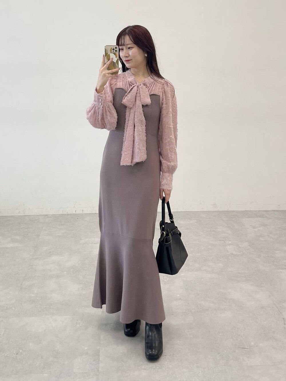 ホワイト系のノーカラーコート、ブラック系のショルダーバッグ、ブラウン系のワンピースを着用したレディースの秋コーディネートの6枚目の写真