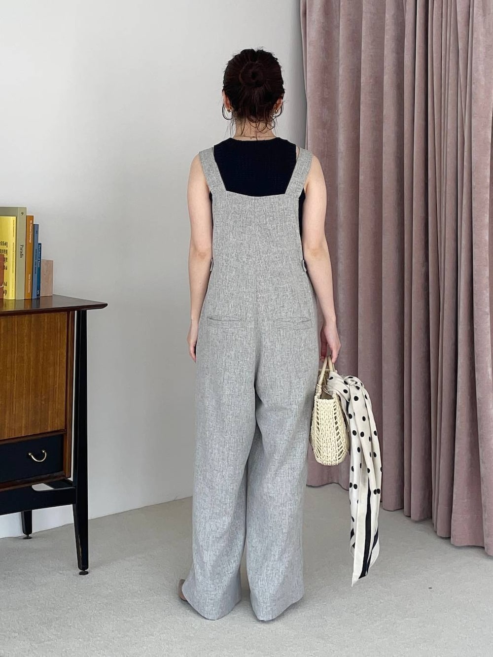 ブラウン系のサンダル、ブラック系のベスト、グレー系のサロペット/オーバーオールを着用したレディースの春コーディネートの2枚目の写真