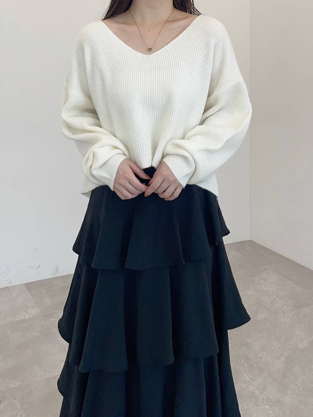 ホワイト系のショルダーバッグ、ホワイト系のブーツ、ブラック系のスカートを着用したレディースの冬コーディネートの3枚目の写真