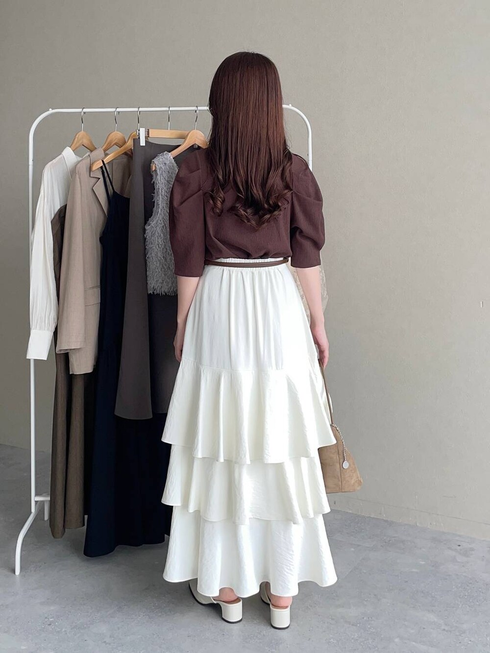 ブラウン系のTシャツ/カットソー、ホワイト系のスカート、ホワイト系のスリッポンを着用したレディースの夏コーディネートの2枚目の写真