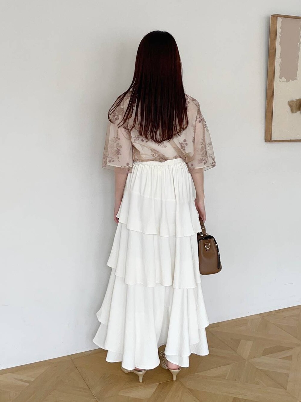 ホワイト系のスカート、ホワイト系のシャツ/ブラウス、ゴールド系のパンプスを着用したレディースの夏コーディネートの2枚目の写真