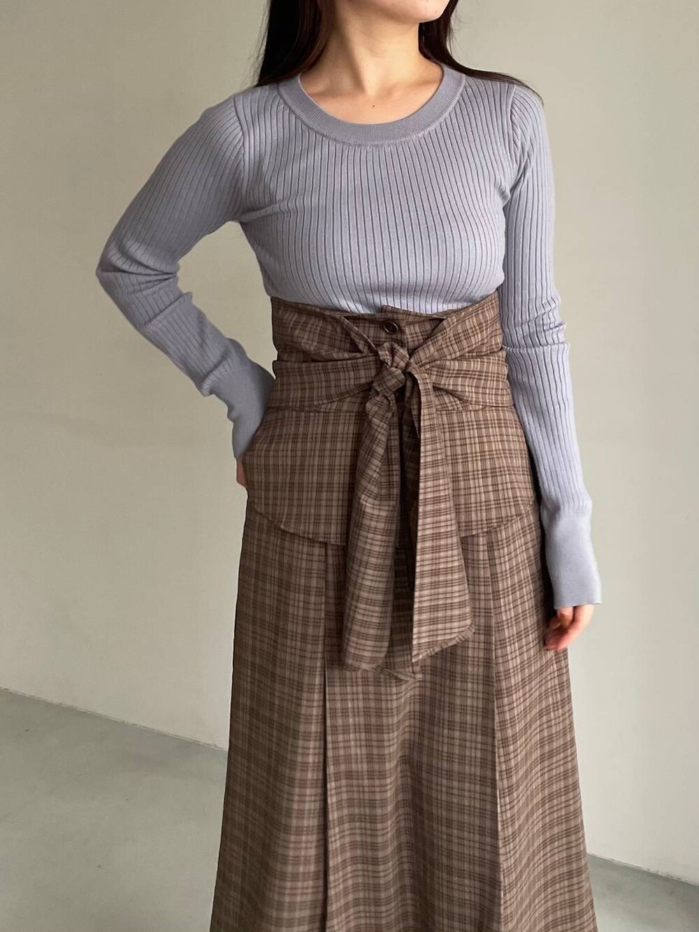 ホワイト系のブルゾン、ホワイト系のブーツ、ブラウン系のスカートを着用したレディースの冬コーディネートの5枚目の写真