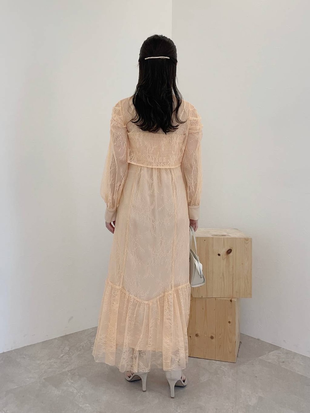 グレー系のパンプス、ホワイト系のボストンバッグ、オレンジ系のドレスを着用したレディースの冬コーディネートの2枚目の写真