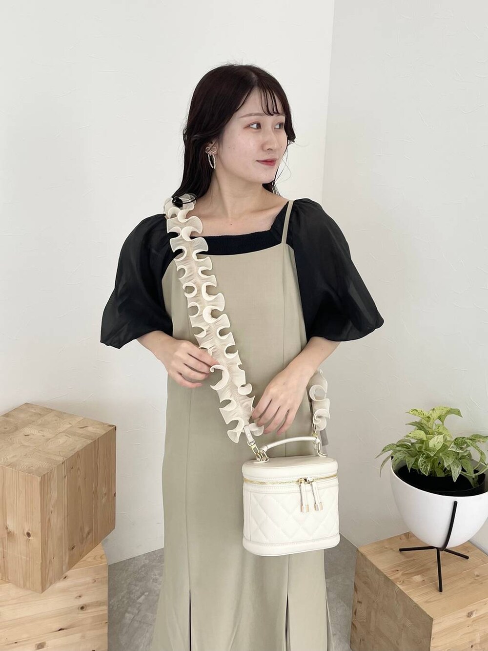 ベージュ系のワンピース、ブラック系のTシャツ/カットソー、ホワイト系のサンダルを着用したレディースの夏コーディネートの3枚目の写真