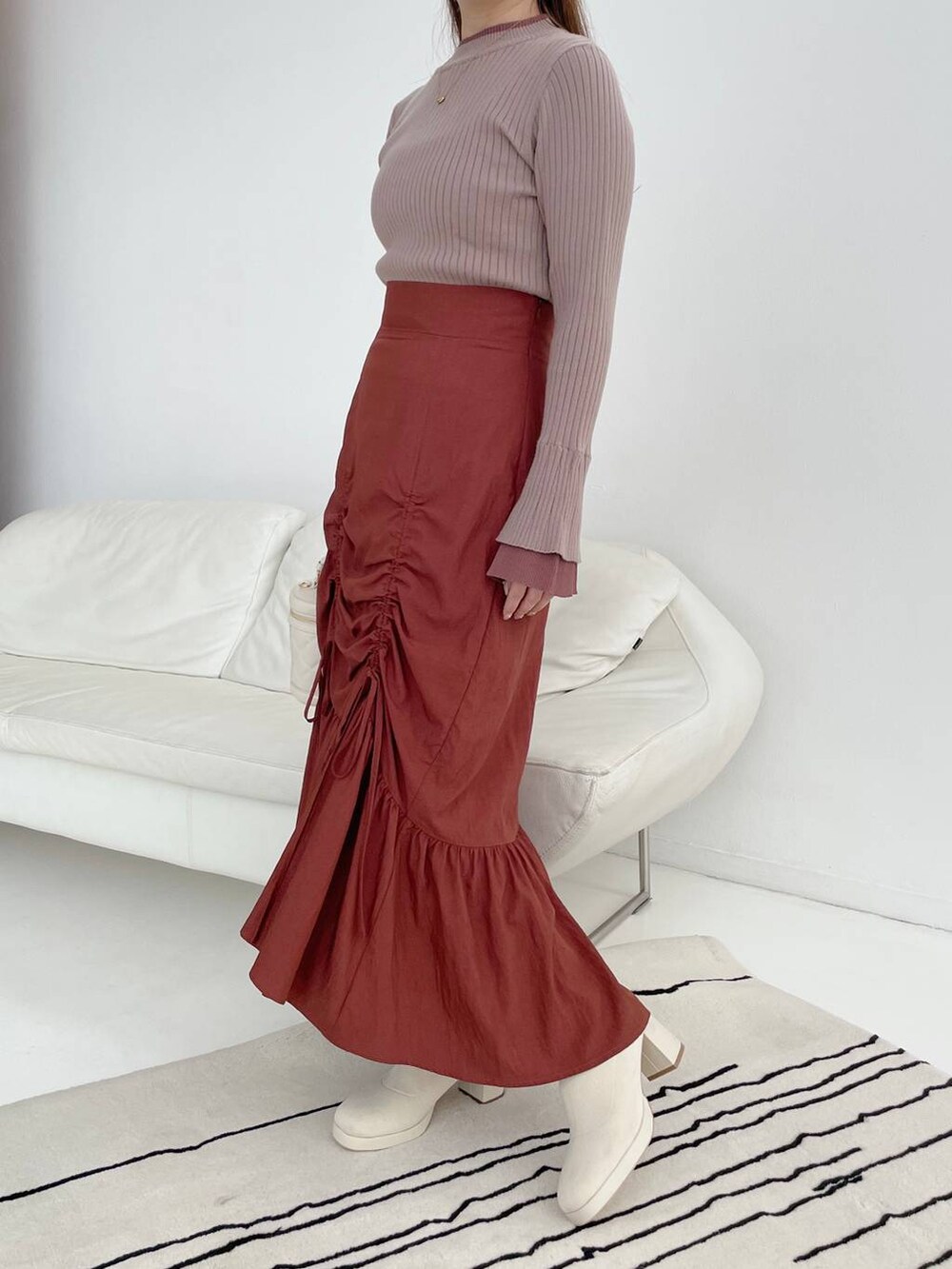 ホワイト系のブーツ、ブラウン系のニット/セーター、ホワイト系のショルダーバッグを着用したレディースの秋コーディネートの4枚目の写真