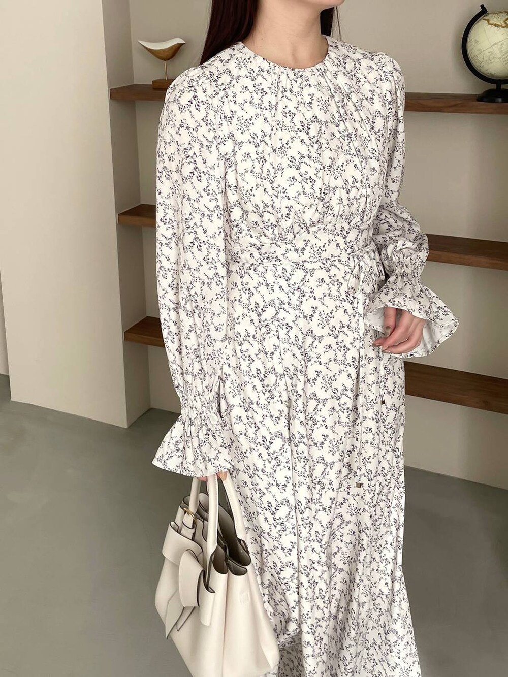 ホワイト系のブーツ、ホワイト系のショルダーバッグ、ホワイト系のワンピースを着用したレディースの冬コーディネートの5枚目の写真